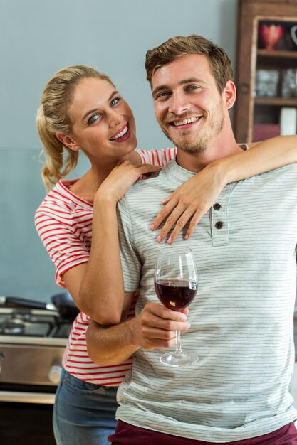 Retrato de la feliz pareja joven de pie en casa