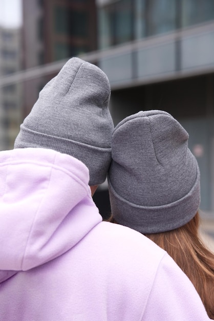 Retrato de una feliz pareja joven con sombreros al aire libre posando ropa de calle urbana