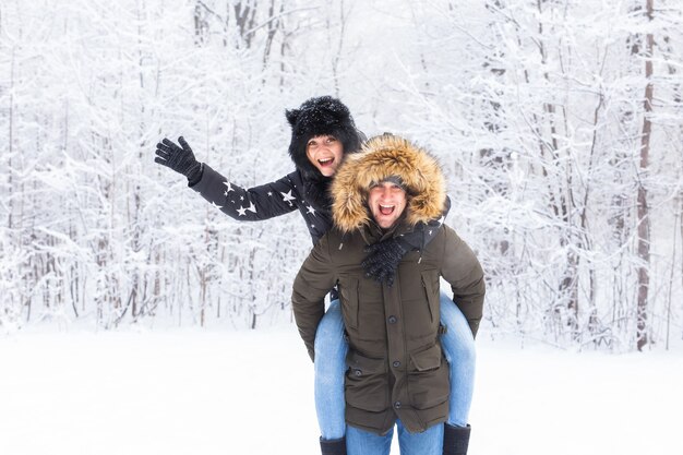 Retrato de la feliz pareja joven en Winter Park con su amigo detrás