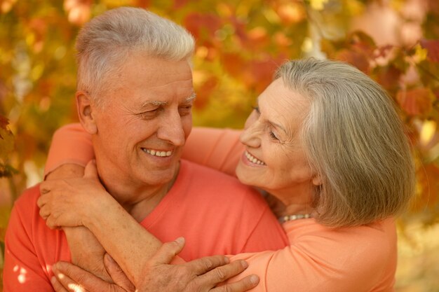 Retrato de una feliz pareja madura en el parque otoño