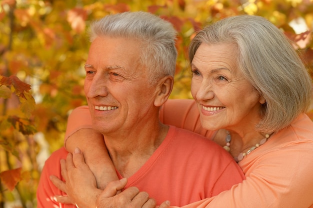 Retrato de una feliz pareja madura en el parque otoño