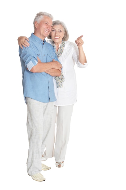 Retrato de feliz pareja senior apuntando a la derecha en fondo blanco.