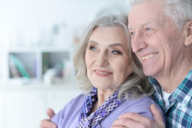 Retrato de feliz pareja senior posando en casa