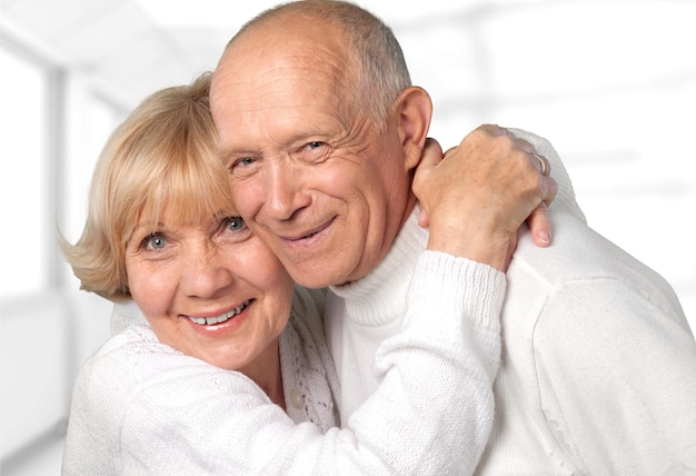 Retrato de feliz pareja senior sonriendo en casa