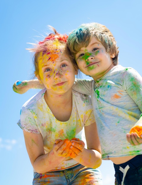 Retrato de feliz pequeña hija e hijo en holi color festival