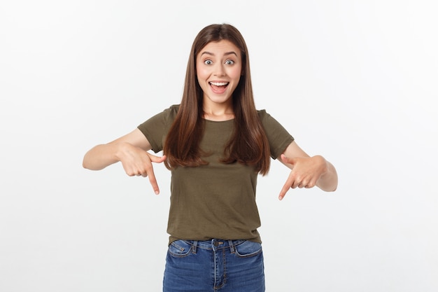 Foto retrato feliz y sorprendida jovencita de pie aislado sobre fondo gris. mirando la cámara apuntando.