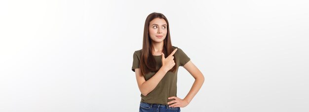 Foto retrato feliz y sorprendida señorita de pie aislada sobre fondo gris mirando la cámara pointi