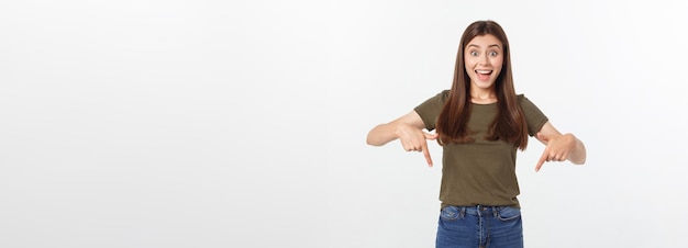 Foto retrato feliz y sorprendida señorita de pie aislada sobre fondo gris mirando la cámara pointi