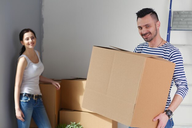 Foto retrato feliz sorridente jovem casal pintando a parede interior da casa nova jovem casal