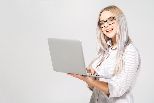 Foto retrato de feliz wow joven y bella mujer sonriente de pie con portátil aislado sobre fondo blanco. espacio para texto.