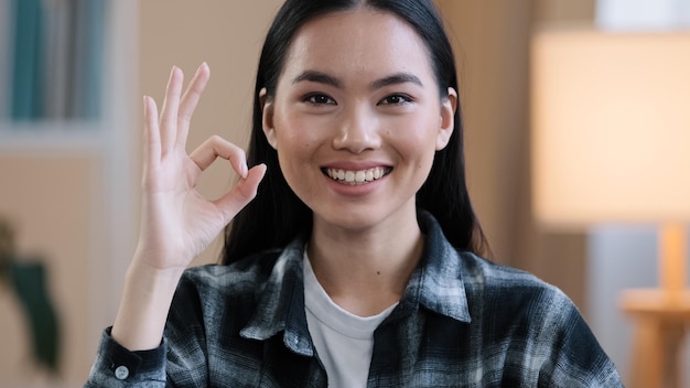 Retrato femenino feliz recomendando sonriente ganador mujer asiática niña mostrando ok gesto todo