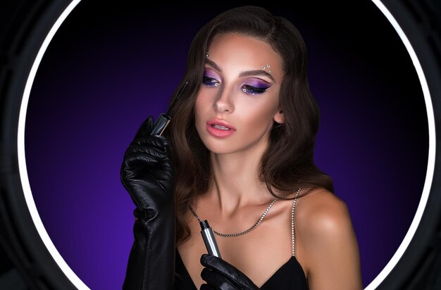 Retrato femenino de una joven morena con un hermoso maquillaje nocturno con sombras moradas en los ojos