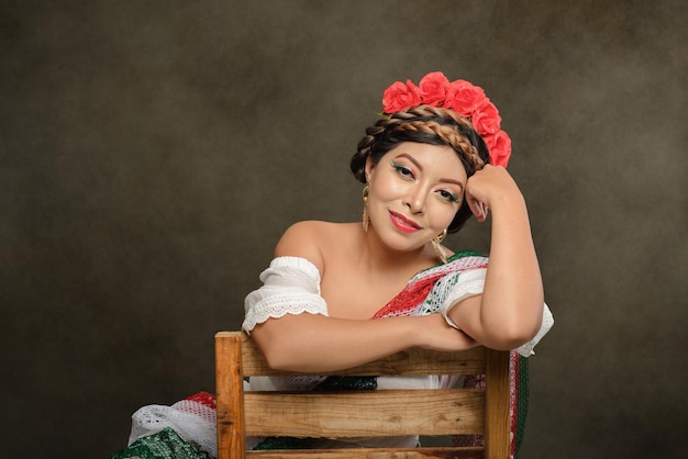 Retrato feminino de estúdio de mulher mexicana com lenço com as cores da bandeira mexicana.