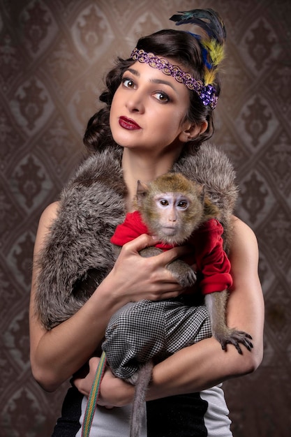 Retrato feminino retrô no estilo dos anos 20 ou 30. Uma linda senhora está segurando um macaquinho.