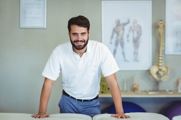 Retrato de fisioterapeuta de pie en la clínica