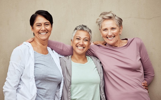 Retrato fitness mulheres idosas amigas e exercícios com bem-estar na vitalidade da aposentadoria e estilo de vida ativo Sorriso feminino maduro e treinamento relaxam e motivação esportiva contra o fundo da parede