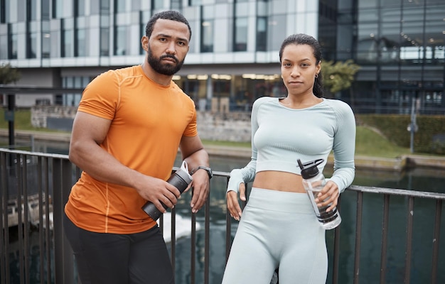 Retrato fitness ou casal negro na cidade para treino relaxar após treino ou com garrafa de água para beber Bem-estar do parceiro ou mulher negra e homem para treinamento esportivo ou pausa para corrida no Canadá