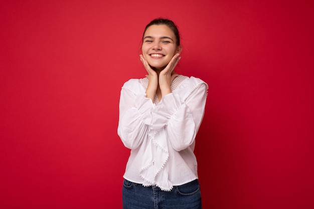 Retrato de la foto de la encantadora mujer morena joven divertida feliz en elegante blusa blanca.