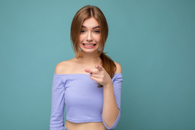 Retrato de la foto de la sonrisa positiva joven agradable hermosa mujer rubia con sinceras emociones vistiendo