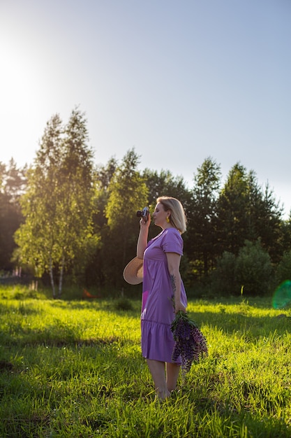 Retrato de una fotografía de niña en un campo floreciente bajo el sol al atardecer