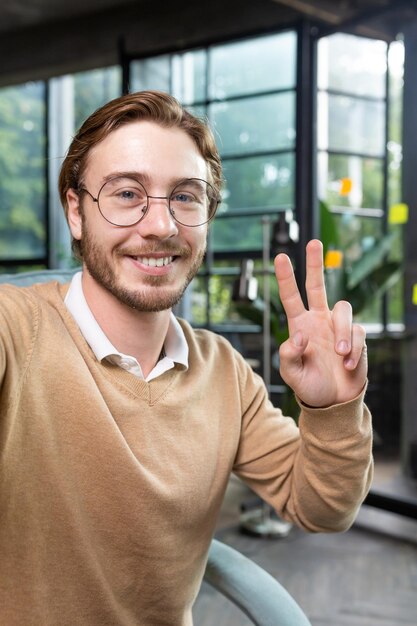 Foto retrato fotográfico aproximado de um hacker programador masculino inteligente profissional tirando selfie com a mão mostrando