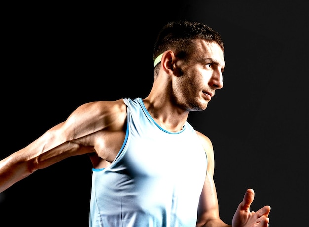 Retrato fotográfico de atleta masculino profesional caucásico entrenamiento de corredor aislado en negro