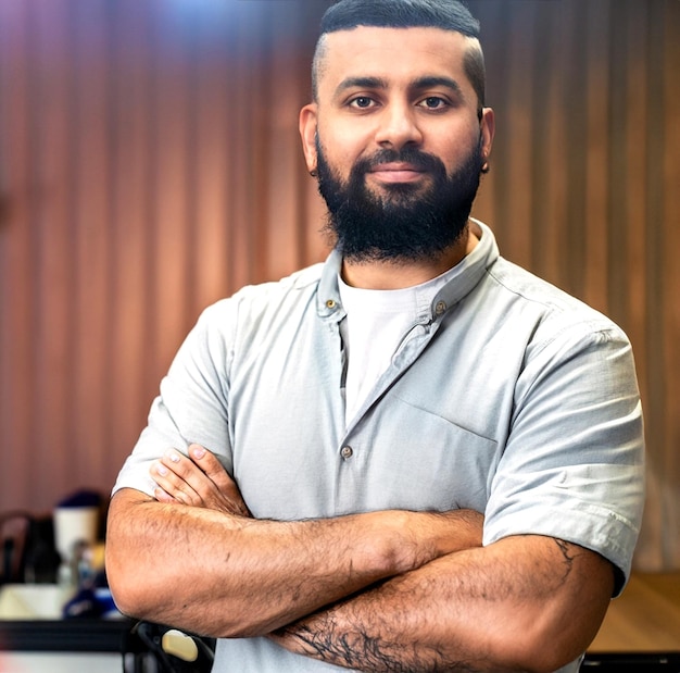 retrato fotográfico de un barbero barbudo adulto con los brazos plegados