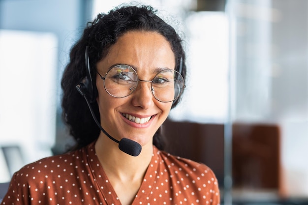 Retrato fotográfico de primer plano de una joven y hermosa mujer latinoamericana en un servicio de centro de llamadas con auriculares