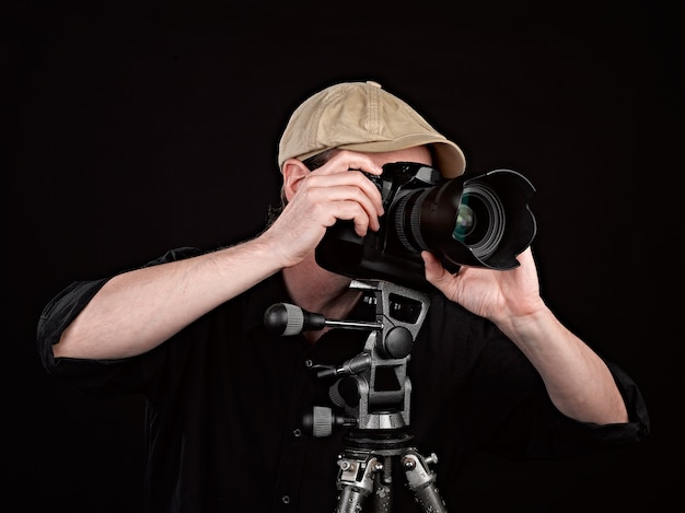 Retrato de un fotógrafo con su cámara en estudio