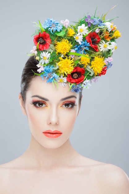 Retrato frontal de una joven llevando un ramo de flores de colores