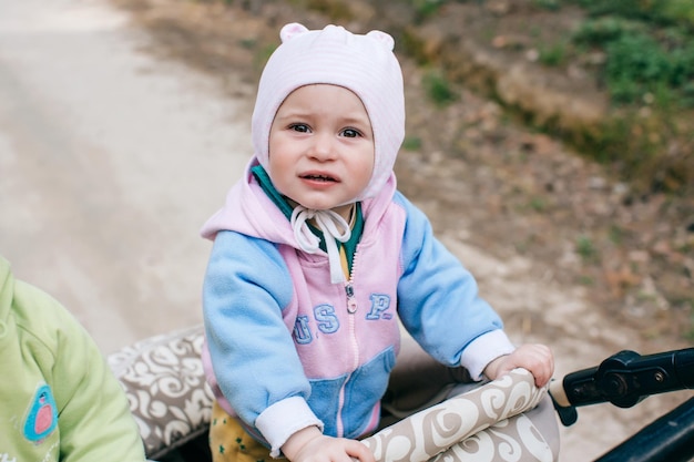 Retrato Funny girl baby en cochecito al aire libre en forestx9