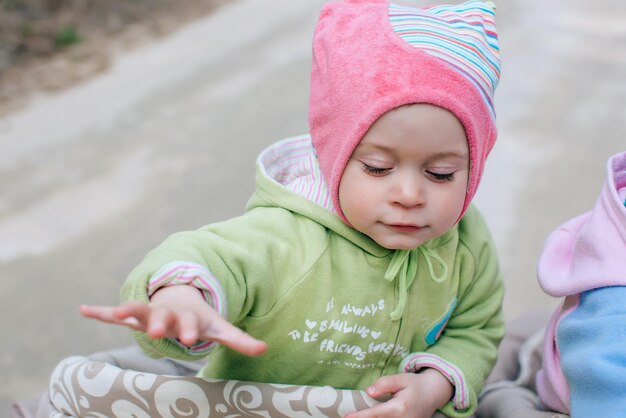 Retrato Funny girl baby en cochecito al aire libre en forestx9