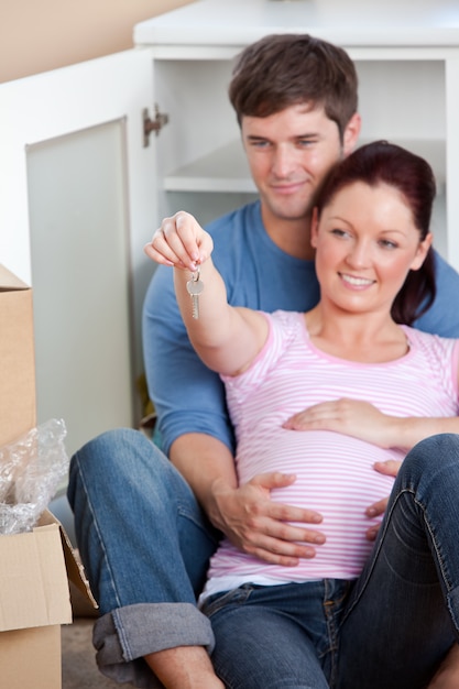 Retrato de futuros padres mirando clave sentado en el piso