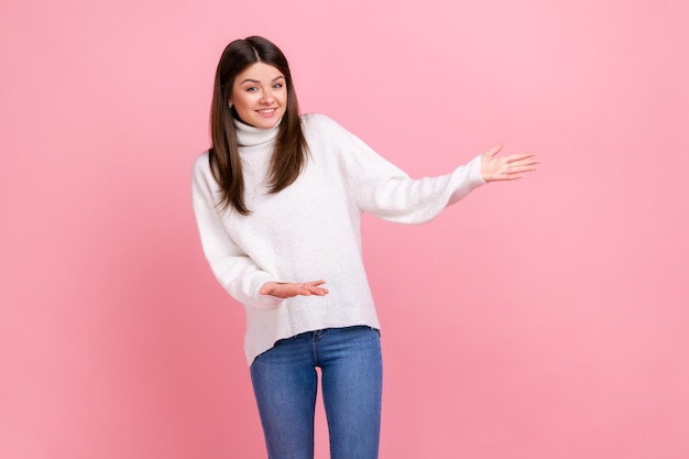 Retrato de una generosa mujer morena de pie con los brazos levantados y dando la bienvenida o compartiendo