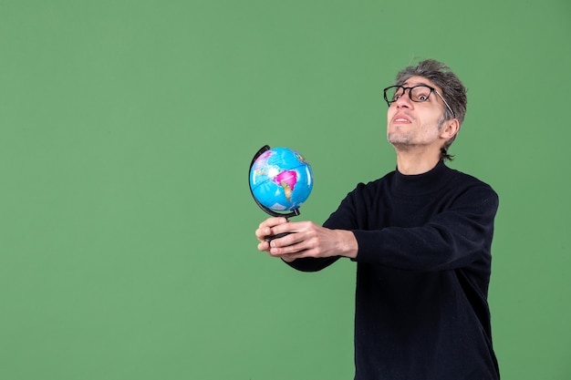 retrato de genio hombre sosteniendo globo terráqueo fondo verde espacio aire planeta naturaleza maestro de escuela mar