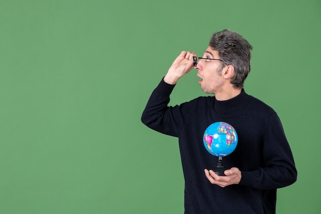 retrato de genio hombre sosteniendo globo terráqueo fondo verde mar naturaleza planeta aire espacio profesor