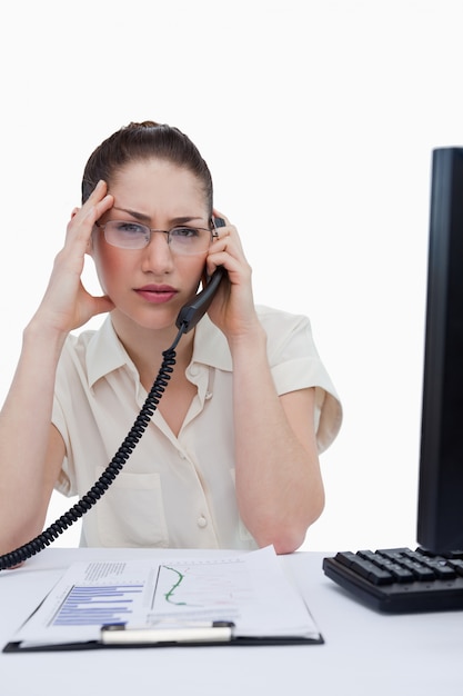 Foto retrato de un gerente cansado haciendo una llamada mientras mira estadísticas