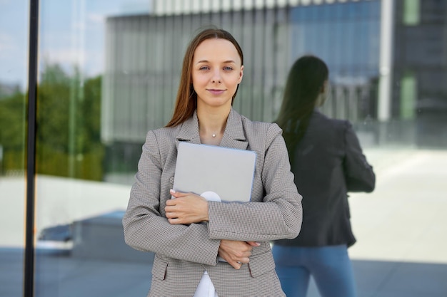 Retrato de un gerente exitoso en una gran empresa internacional Una mujer con una computadora portátil afuera