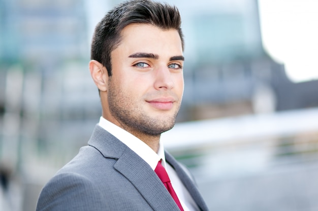 Retrato de un gerente joven guapo al aire libre