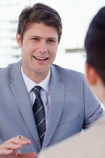 Retrato de un gerente sonriente entrevistando a un solicitante femenino