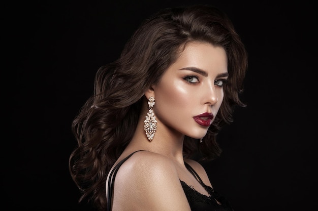 Retrato glamoroso da moda de uma garota em um fundo escuro Penteado elegante maquiagem brilhante e cor dos lábios Imagem de Hollywood
