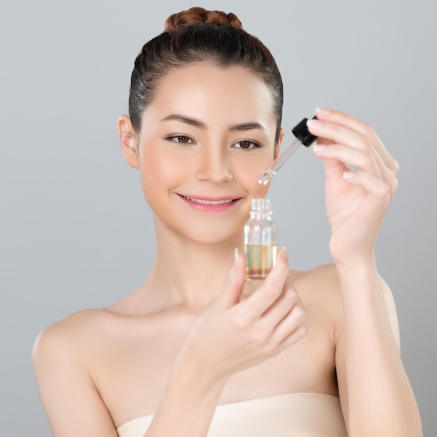 Retrato glamoroso de mulher aplicando tratamento de cuidados com a pele com óleo CBD