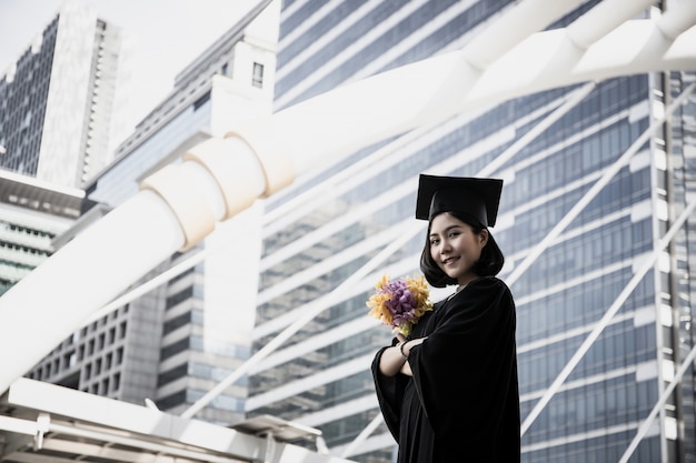 Retrato del graduado asiático del estudiante que es felicitado.