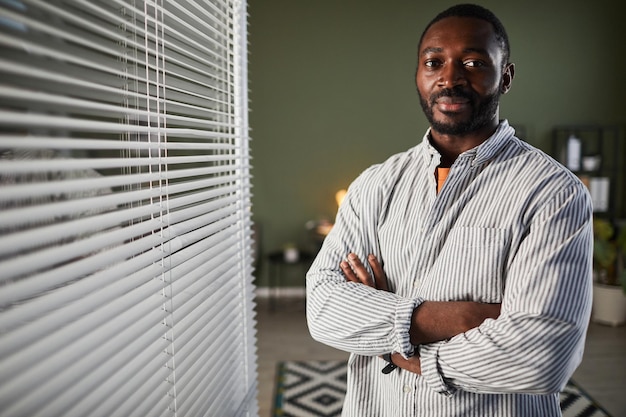 Retrato gráfico de cintura para arriba de un exitoso hombre de negocios afroamericano de pie con los brazos cruzados en o