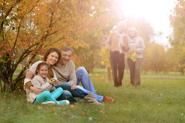 Retrato de una gran familia descansando en un picnic en el parque de otoño