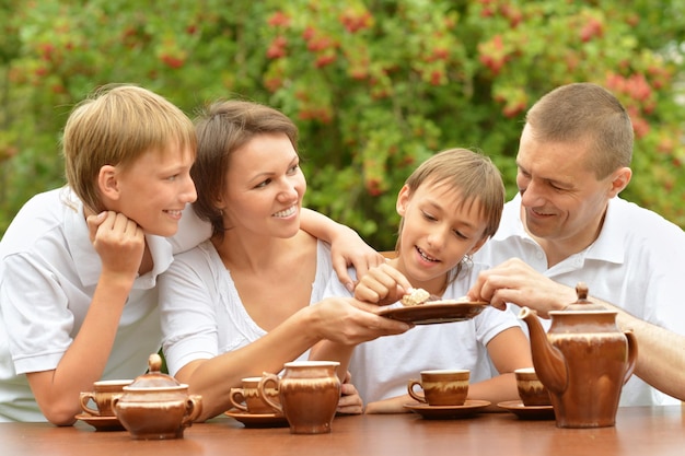 Retrato de gran familia feliz bebiendo té al aire libre