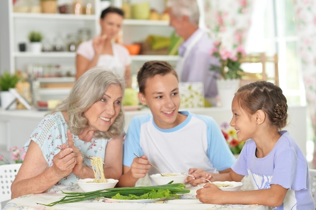 Retrato de una gran familia feliz desayunando