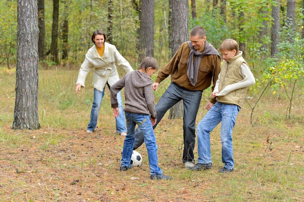 Retrato de una gran familia feliz jugando al fútbol en el parque