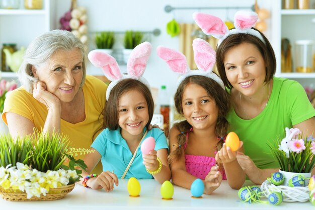 Retrato de una gran familia feliz pintando huevos de Pascua tradicionales