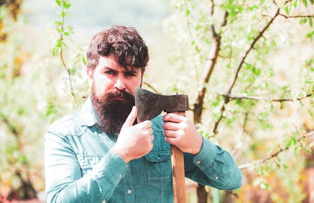 Retrato de granjero barbudo con hacha tierra agrícola primavera y pasatiempos jardinero eco granjero